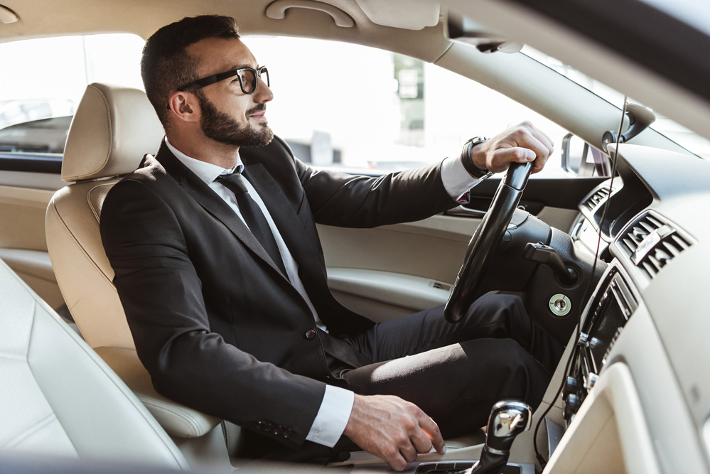 Businessman in suit driving car