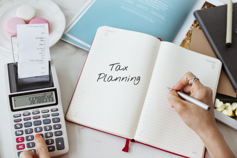 Tax planning written in notebook next to calculator